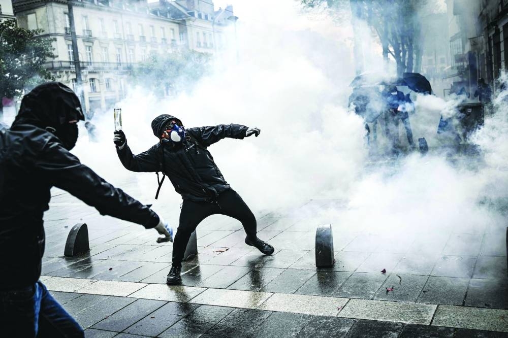 A protester throws a bottle at police during a demonstration in Nantes, western France.