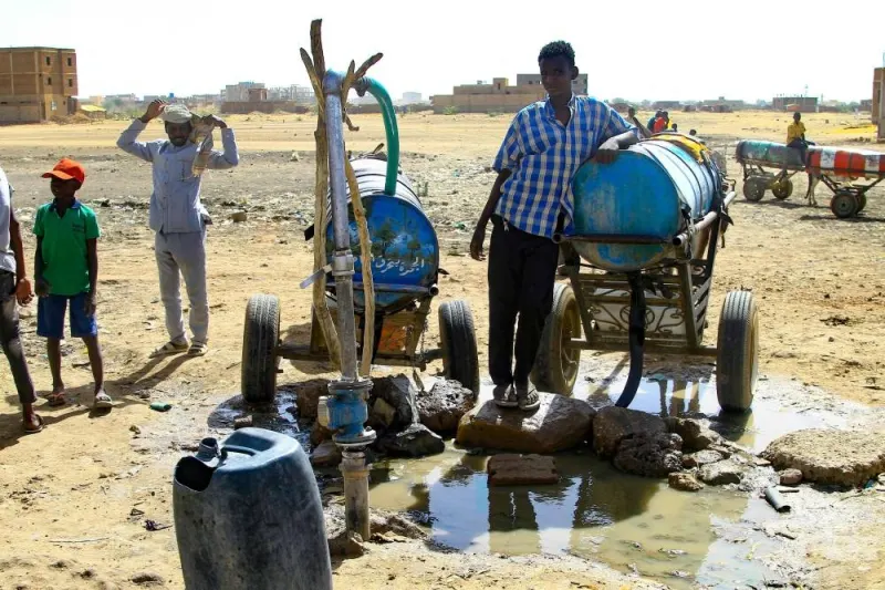 People fill barrels with water in southern Khartoum, amid water shortages caused by ongoing battles between the forces of two rival Sudanese general. AFP