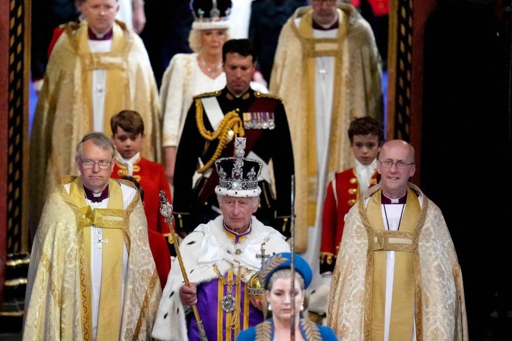 Britain&#039;s King Charles III wearing the Imperial state Crown, and Queen Camilla, wearing a modified version of Queen Mary&#039;s Crown leave Westminster Abbey after the Coronation Ceremonies in central London. AFP