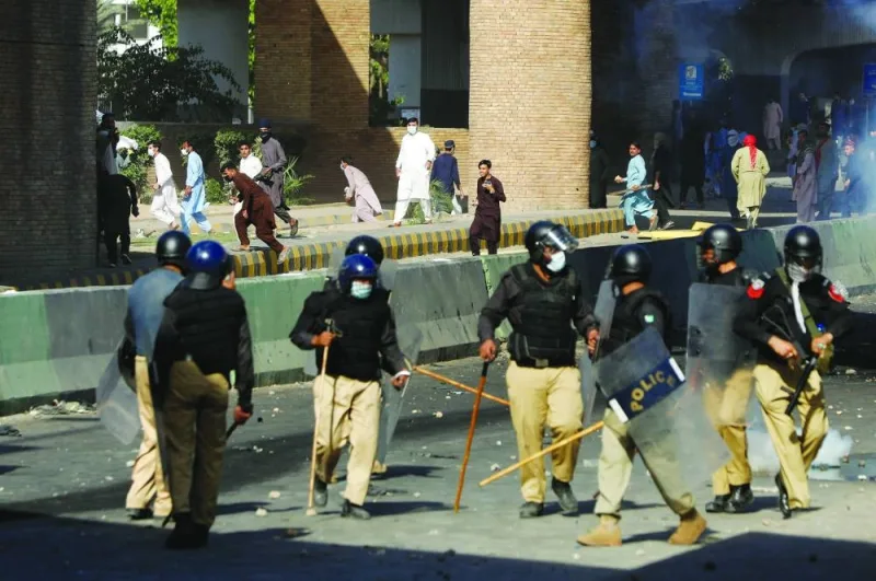 Supporters of Pakistan’s former prime minister Imran Khan throw stones towards police during a protest against Khan’s arrest, in Peshawar, yesterday.