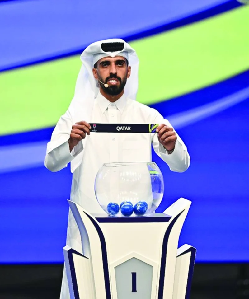 Qatar captain Hassan al-Haydos draws the name of Qatar during the draw Thursday.