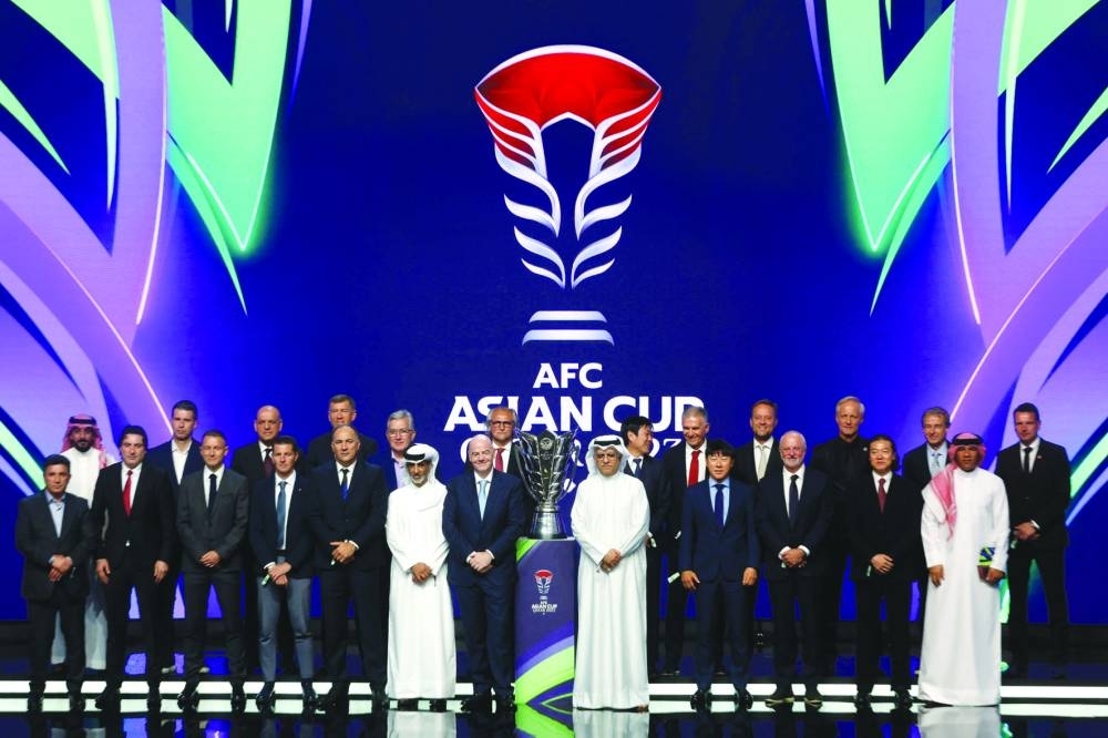 Gianni Infantino, Sheikh Salman bin Ebrahim al-Khalifa and HE Sheikh Hamad bin Khalifa bin Ahmed al-Thani pose with the trophy and coaches during the draw in Doha Thursday.
