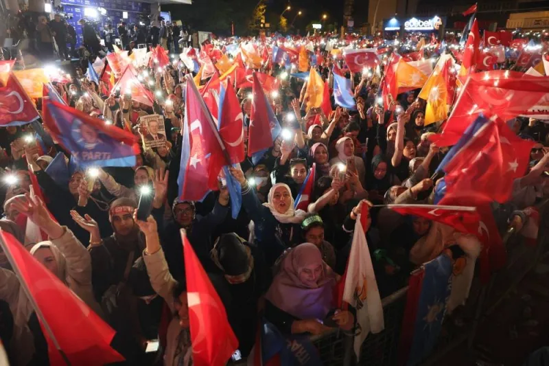 Supporters of Turkish President Tayyip Erdogan wave flags outside the AK Party headquarters after polls closed in Turkiye&#039;s presidential and parliamentary elections in Ankara. Adem ALTAN / AFP
