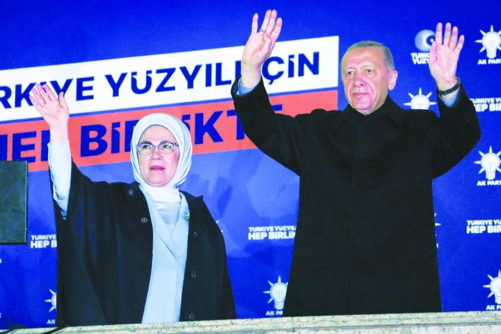 Turkish President Tayyip Erdogan, accompanied by his wife Ermine, waves to supporters at the AK Party headquarters in Ankara yesterday. (AFP)