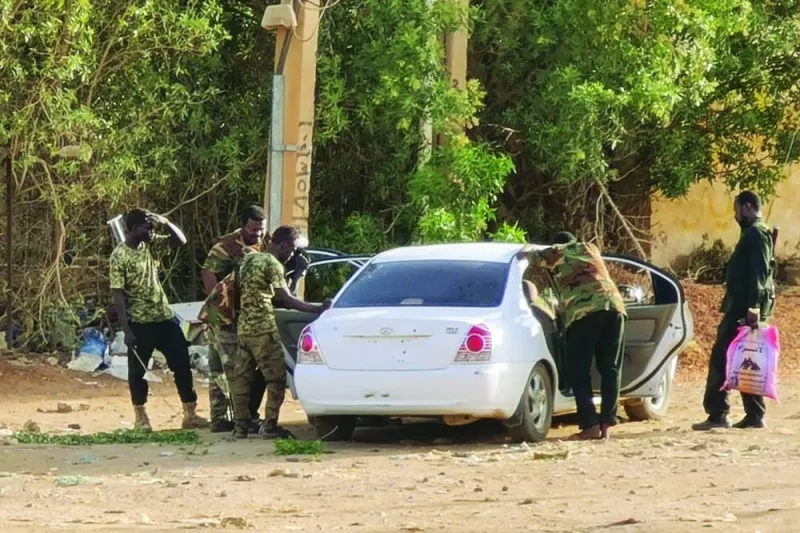 Members of Sudanese security forces affiliated with the army search a car without a licence plate in Khartoum, on Saturday.