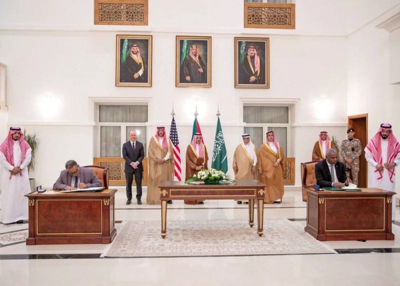 Saudi Foreign Minister Prince Faisal bin Farhan bin Abdullah Al-Saud stands along with other officials as representatives of the Sudanese army and rival paramilitary Rapid Support Forces sign an agreement for a seven-day ceasefire in Jeddah, Saudi Arabia, Saturday. Saudi Press Agency/Handout via REUTERS