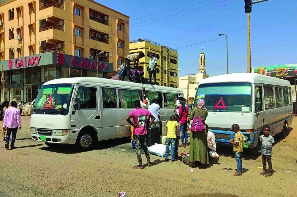 People board a bus as they evacuate southern Khartoum, on Tuesday after a one-week ceasefire officially went into force.