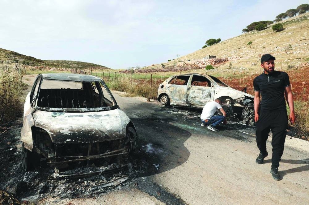 Palestinians inspect cars, reportedly burnt by settlers, in the village of Al-Mughayyir, east of the occupied West Bank city of Ramallah, on Friday.
