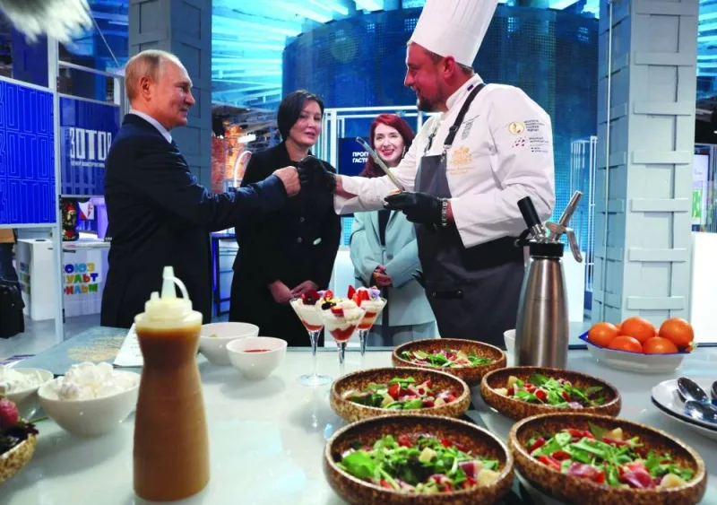 Russian President Vladimir Putin greets chef Andrei Savenkov as he visits the “Development of Creative Economy in Russia” exhibition in Moscow on Tuesday. (Reuters)
