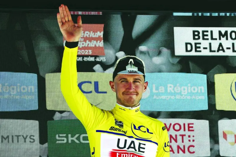 Mikkel Bjerg celebrates in the yellow jersey of the overall leader after winning the fourth stage of the Criterium du Dauphine cycling race in Belmont-de-la-Loire, France, on Wednesday. (AFP)