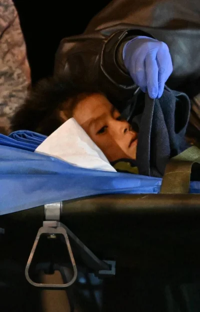 One of the four Indigenous children who were found alive after being lost for 40 days in the Colombian Amazon forest following a plane crash, is stretchered out of a plane upon landing at the CATAM military base in Bogota on June 10, 2023.  Juan BARRETO / AFP
