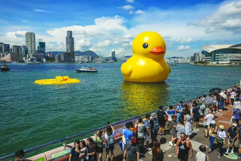 People visit the Double Ducks installation after one of the ducks deflated on Saturday.