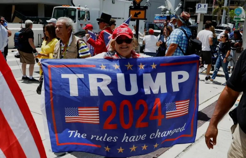 A supporter of former US President Donald Trump holds a banner near the Wilkie D. Ferguson Jr. United States Courthouse, on the day Trump is to appear at his arraignment on classified document charges, in Miami, Florida. REUTERS/Marco Bello