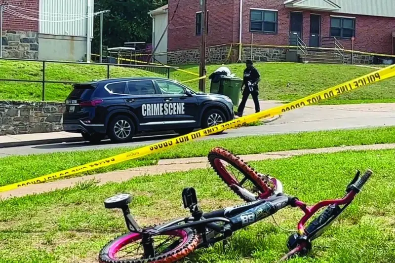 A police officer is seen near a child’s bicycle after a mass shooting at the scene of a Fourth of July holiday weekend block party in Baltimore, Maryland. The suspect or suspects remain at large.