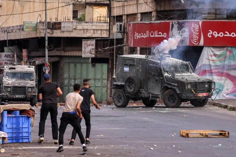 An Israeli armoured vehicle fires riot control grenades in clashes with Palestinians during an Israeli military raid in the old city of Nablus in the occupied West Bank Friday.