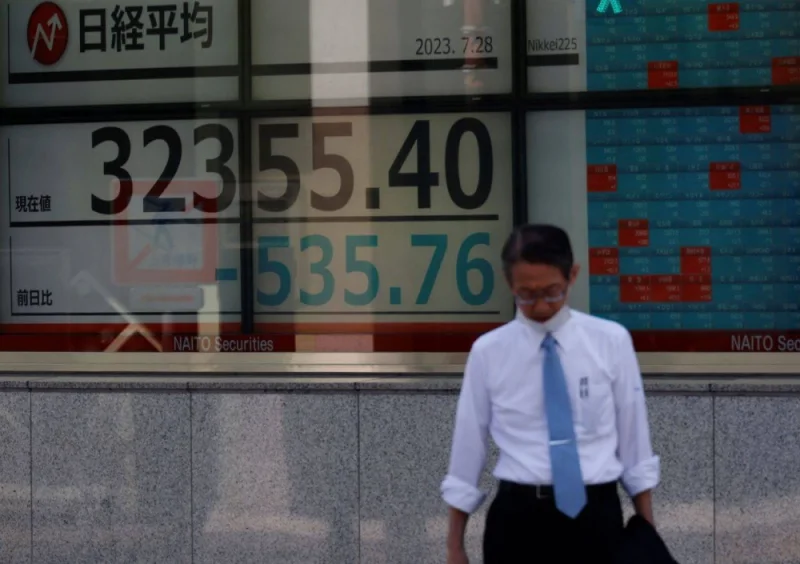 A man stands in front of an electric board displaying the Nikkei stock average outside a brokerage in Tokyo, Japan, July 28, 2023. REUTERS/Kim Kyung-Hoon