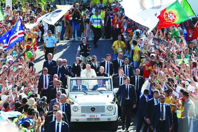 
Pope Francis waves to the crowd on arrival to take part in the welcome ceremony on the Meeting Hill at Parque Eduardo VII in Lisbon. 