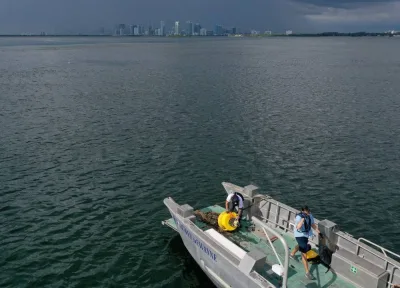 In an aerial view, (L-R) Nick Evans and Bradley Schonhoff conduct routine maintenance on a research buoy in Biscayne Bay on August 03 in Miami, Florida. Evans is Florida International University&#039;s Greater Biscayne Bay Research Program Sensor & Lab Manager, and Schonhoff is the Program Manager NSF CREST Center for Aquatic Chemistry and Environment Institute of Environment at Florida International University. The buoy measures the bay waters&#039; PH, temperature, conductivity (for salinity), dissolved oxygen, turbidity, chlorophyll, fluorescent dissolved organic matter, and directional flow speed. As some areas of South Florida experience record rising ocean water temperatures, researchers use the information from the buoy to monitor the bay&#039;s health. Joe Raedle/Getty Images/AFP 