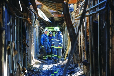 Firefighters walk along a burnt-out building of the University of Economics and Trade, which was reportedly hit by shelling in Donetsk, Russian-controlled Ukraine, yesterday. (Reuters)