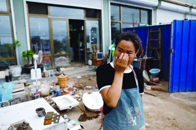 Li Yujie, 47, weeps outside her flood-stricken hardware store after the rains and floods brought by remnants of Typhoon Doksuri, in Zhuozhou, Hebei province, China, on Monday.