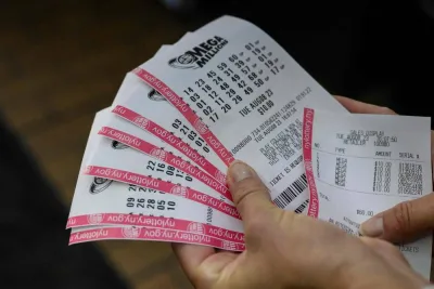 A person holds up their Mega Millions lottery tickets in New York City. 