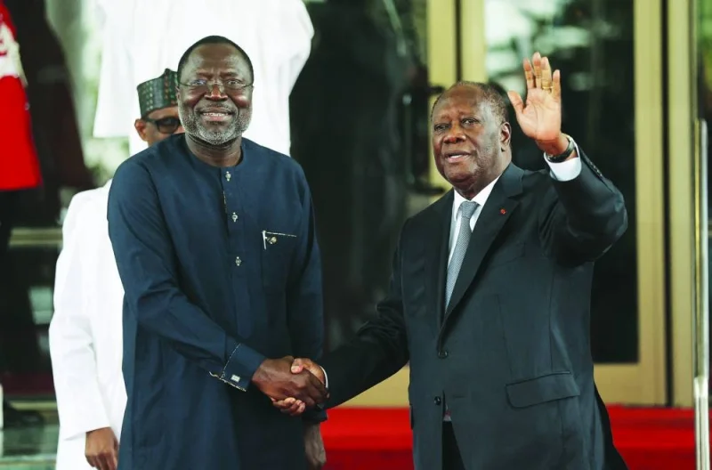 
Ivory Coast President Alassane Ouattara (right) waves to the press upon his arrival in Abuja. 
