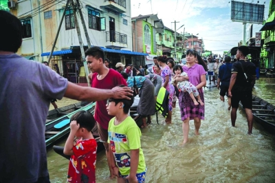 Residents wade through a flooded street following monsoon rains in Bago township, Bago region, Myanmar, on Friday.
