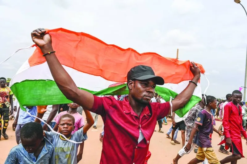 Supporters of Niger’s National Council for the Safeguard of the Homeland (CNSP) hold Niger and Russian flags as they gather for a demonstration in Niamey near a French air base in Niger.