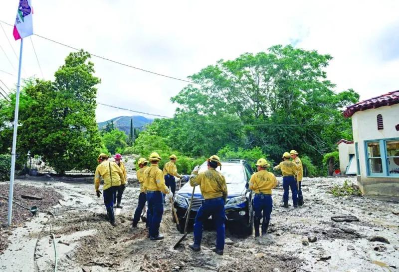 
CalFire personnel help clear mud and debris for residents stuck in their home in Yucaipa, California. 