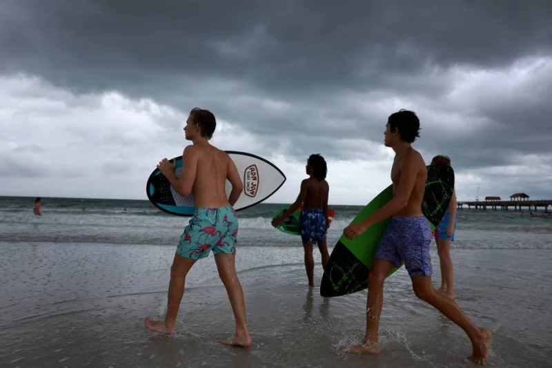 Storm clouds hang over people as they enjoy the beach before the possible arrival of Hurricane Idalia on August 29, 2023 in Clearwater Beach, Florida. AFP