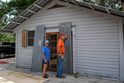 Renda Doherty (L) with her husband William Doherty board their house in preparation for Hurricane Idalia, in Steinhatchee, Florida. AFP
