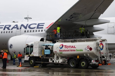 Workers connect a Total tanker truck to an Airbus A350 passenger plane, operated by Air France-KLM, during fuelling with sustainable aviation fuel,   at Charles de Gaulle airport in Roissy, France. SAF is considered a critical component in reducing the aviation industry&#039;s carbon footprint and achieving sustainability goals.