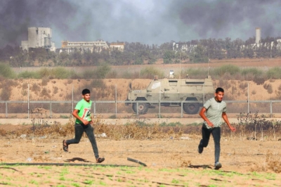 
Palestinian demonstrators run for cover during clashes with soldiers along the Israel-Gaza border, east of Khan Yunis town in the southern Gaza Strip, yesterday. 