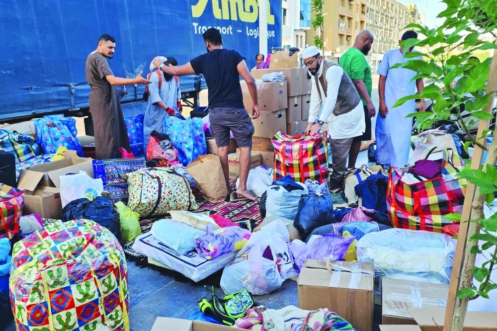 
People bring donated supplies to a collection point in Libya’s capital Tripoli, yesterday, before their transfer to aid affected residents following devastating floods in eastern cities. 