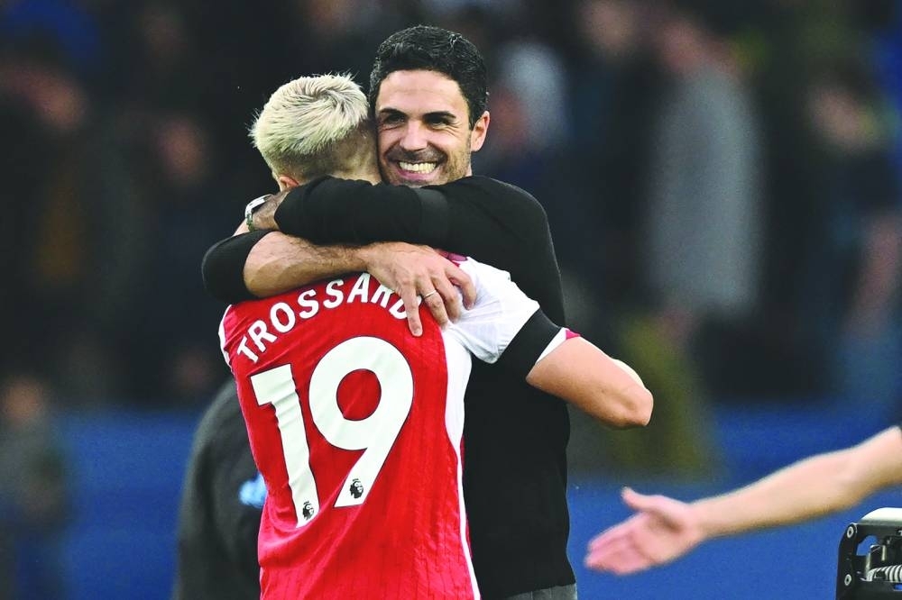 Arsenal’s midfielder Leandro Trossard is embraced by Arsenal’s manager Mikel Arteta after their EPL match against Everton at Goodison Park in Liverpool yesterday. (AFP)