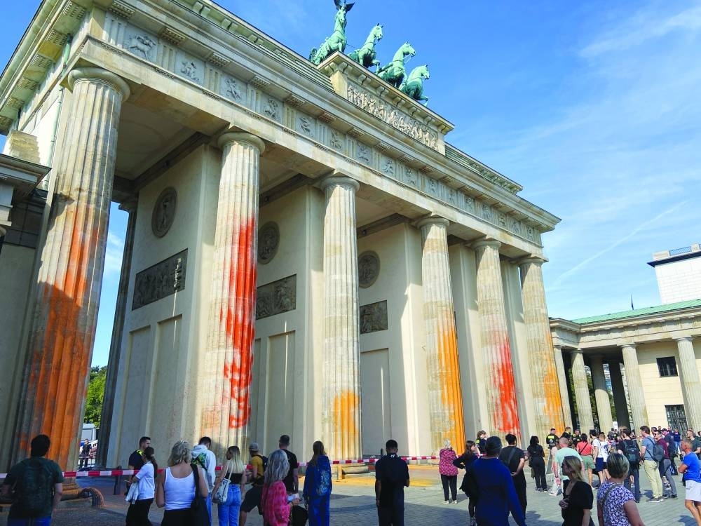 
People walk in front of the Brandenburg Gate after Last Generation climate activists threw paint on the columns of the Brandenburg Gate in Berlin yesterday. (Reuters) 