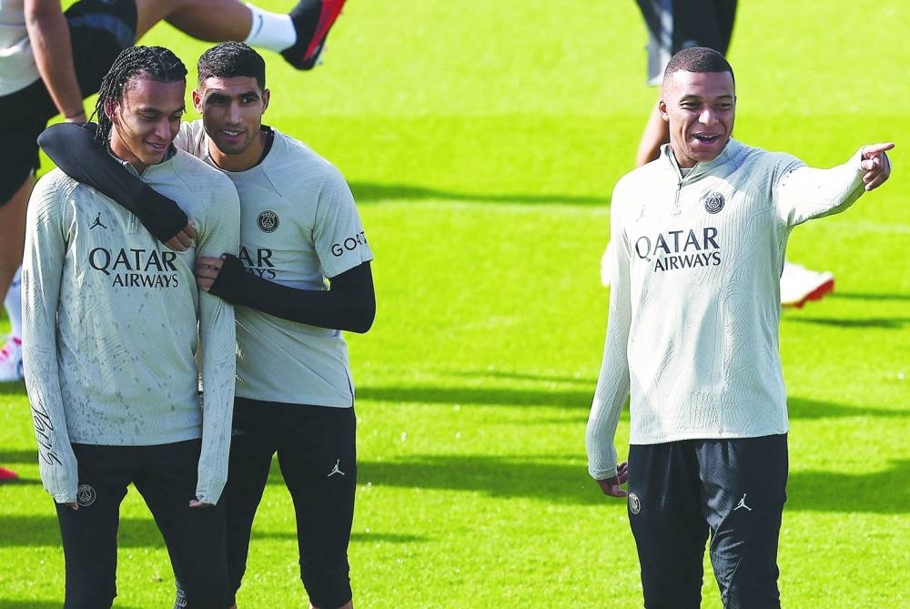 Paris Saint-Germain’s Kylian Mbappe (right) during a training session with his brother Ethan Mbappe (left) and Achraf Hakimi at Poissy, west of Paris on Monday, on the eve of their UEFA Champions League match against Borussia Dortmund. (AFP)