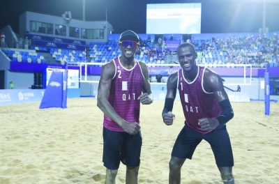 Qatar’s Ahmed Tijan (right) and Cherif Younousse celebrate after winning their beach volleyball quarter-finals against Iran’s Bahman Salemi and Sina Shoukati at the Hangzhou Asian Games on Monday.
