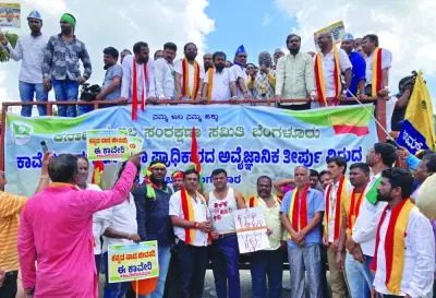 Demonstrators hold placards next to a banner as they attend a protest against the sharing of Cauvery river water with neighbouring Tamil Nadu state, in Bengaluru, India, yesterday. The banner and placards read: “Protest against the unscientific decision taken by authorities on Kaveri”, “Kannada land’s life-giving river, this Kaveri” and “Kaveri is ours”.