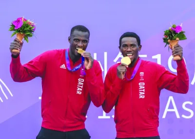 Qatar’s beach volleyball stars Cherif Younousse (left) and Ahmed Tijan pose with their gold medals in Hangzhou, China, on Thursday.