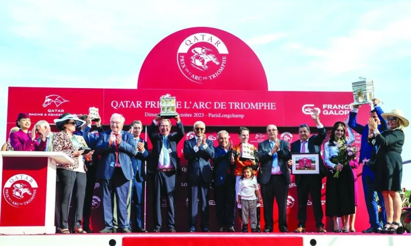 Connections of Ace Impact celebrate with trophies after winning the Qatar Prix de l’Arc de Triomphe on Sunday.