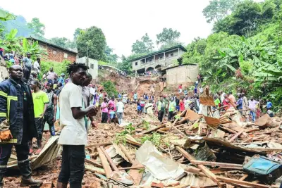 Residents look at the destruction caused by a landslide due to heavy rains in the district of Mbankolo, northwest of Yaounde, on Monday.