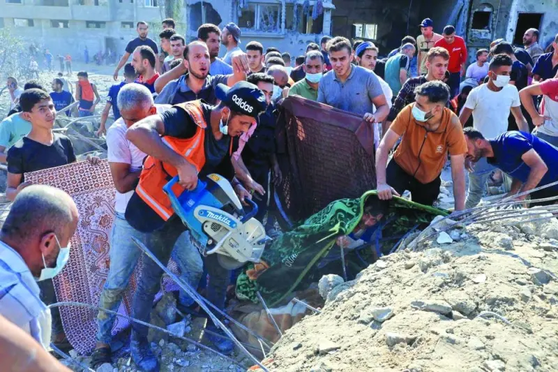 
Palestinians work to clear the rubble of a collapsed building following an Israeli airstrike in Rafah, in the southern of Gaza Strip, yesterday. 