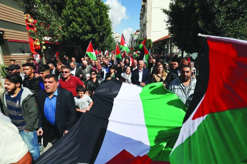 
Palestinians wave the national flag during a march in the West Bank city in Ramallah yesterday, to express solidarity with the Gaza Strip. 