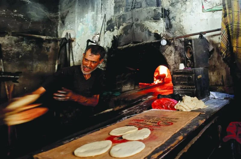 
A Palestinian bakes bread on firewood, amid fuel and power shortages, amid the conflict, in Khan Yunis in the southern Gaza Strip, yesterday. 