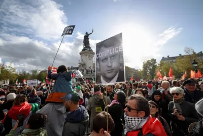 A protestor holds a placard with an image of French President Emmanuel Macron with "Accomplice" written over it during a demonstration calling for peace in Gaza at Place de la Republique in Paris, Sunday. AFP