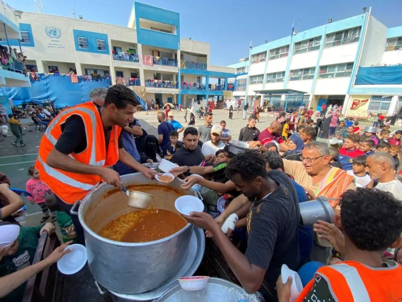 Palestinians, who fled their houses due to Israeli strikes, gather to get their share of charity food offered by volunteers, amid food shortages, at a UN-run school where they take refuge, in Rafah, in the southern Gaza Strip, on Monday. REUTERS