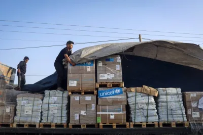 A man unloads humanitarian aid on a convoy of lorries entering the Gaza Strip from Egypt via the Rafah border crossing on Saturday. AFP