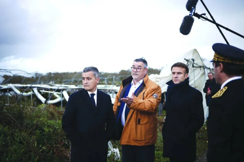 French President Emmanuel Macron (right), French Interior Minister Gerald Darmanin (left), and Finistere prefect Alain Espinasse (centre) visit a farm in a region hit by Storm Ciaran in Daoulas, western France.