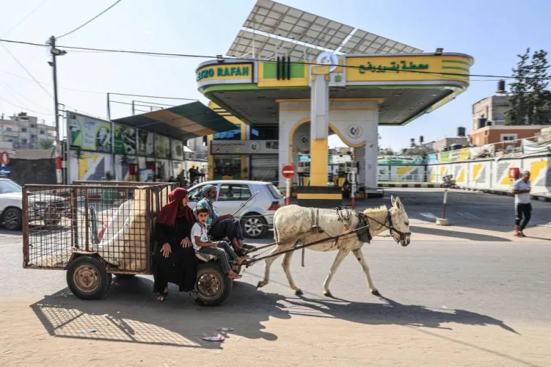 A Palestinian family on a donkey-drawn cart passes a closed petrol station in Rafah in the southern Gaza Strip on Sunday. AFP